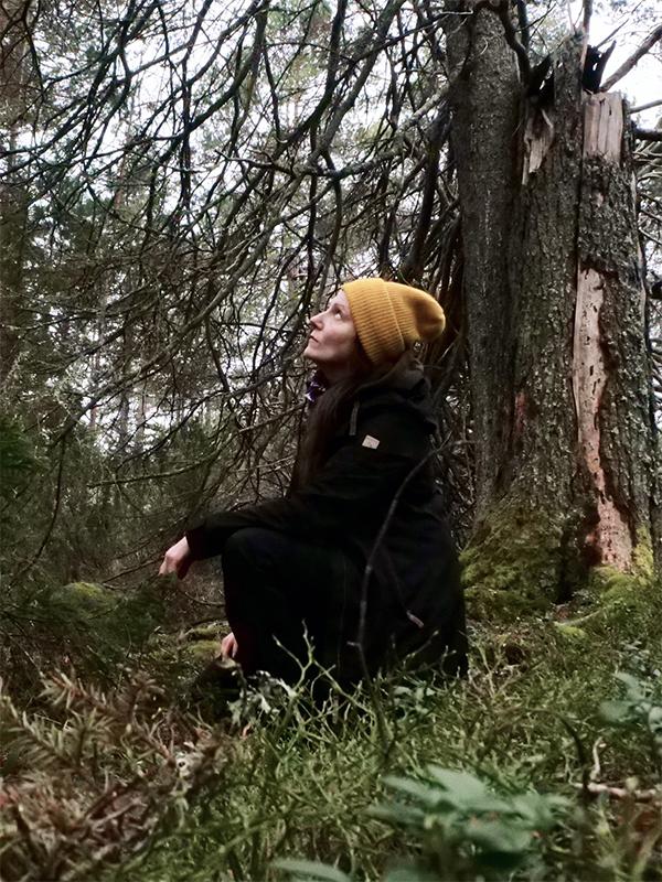Konstnären Johanna Lonka sittande i skogen
